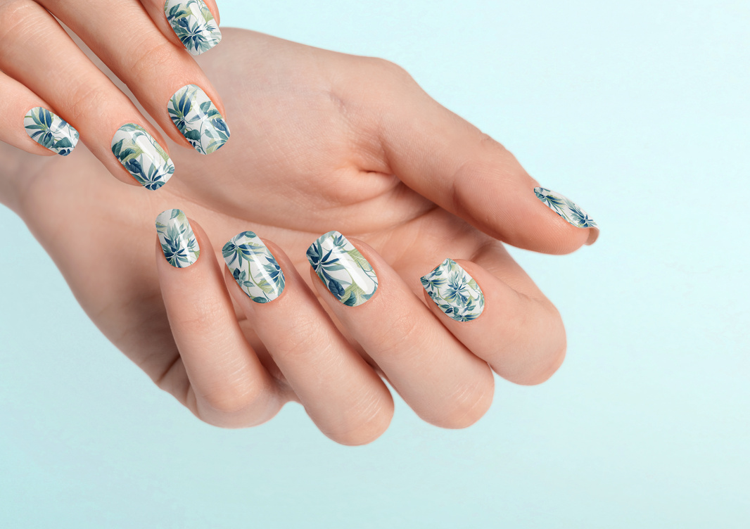 Beautiful female hands with light blue leaf manicure